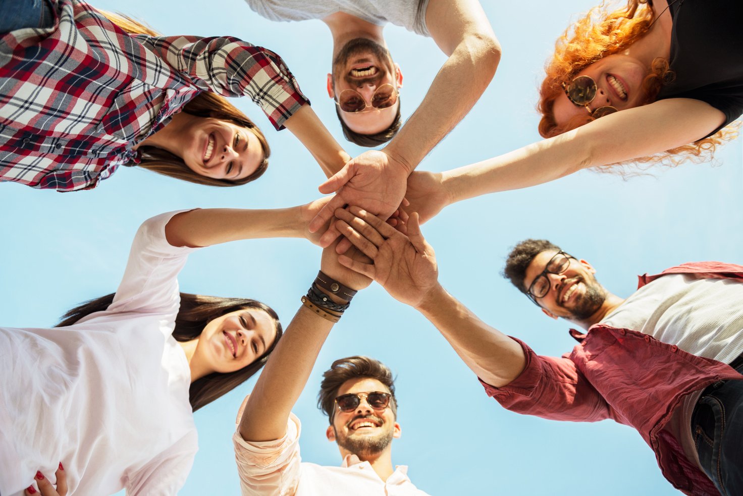 Group of young people standing in a circle, outdoors, having fun